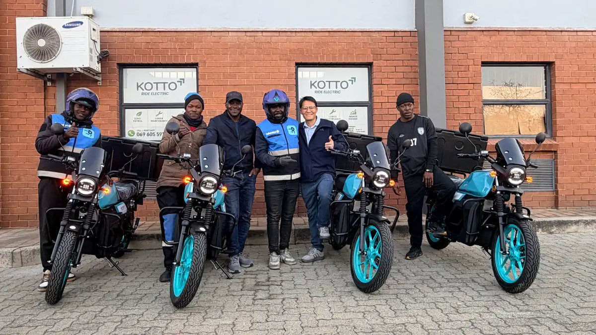 MOTAWILL delivery riders standing with TYCORUN E67 electric motorcycles outside a brick building in South Africa
